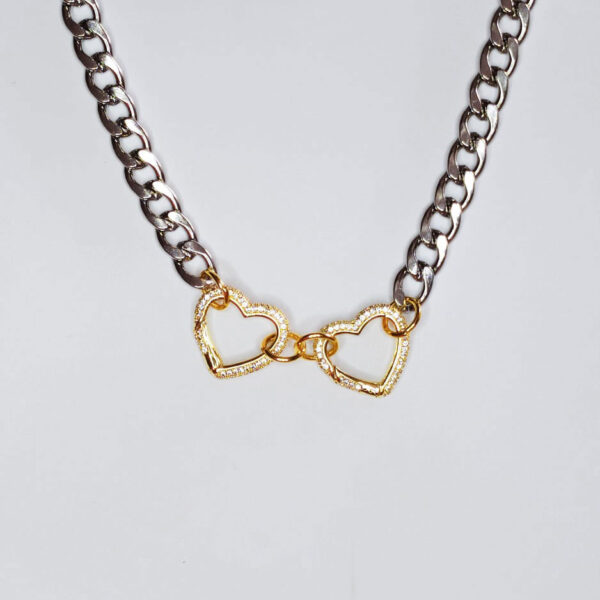 Colar com fio largo prateado em aço e 2 aloquetes em forma de coração em cobre dourado cobertos com zircónias brancas