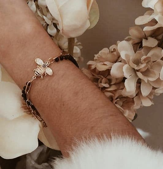 Pulseira com dois fios (um de missangas pretas e outro de argolas estreitas douradas em aço) com pendente em forma de abelha em cobre e zircónias