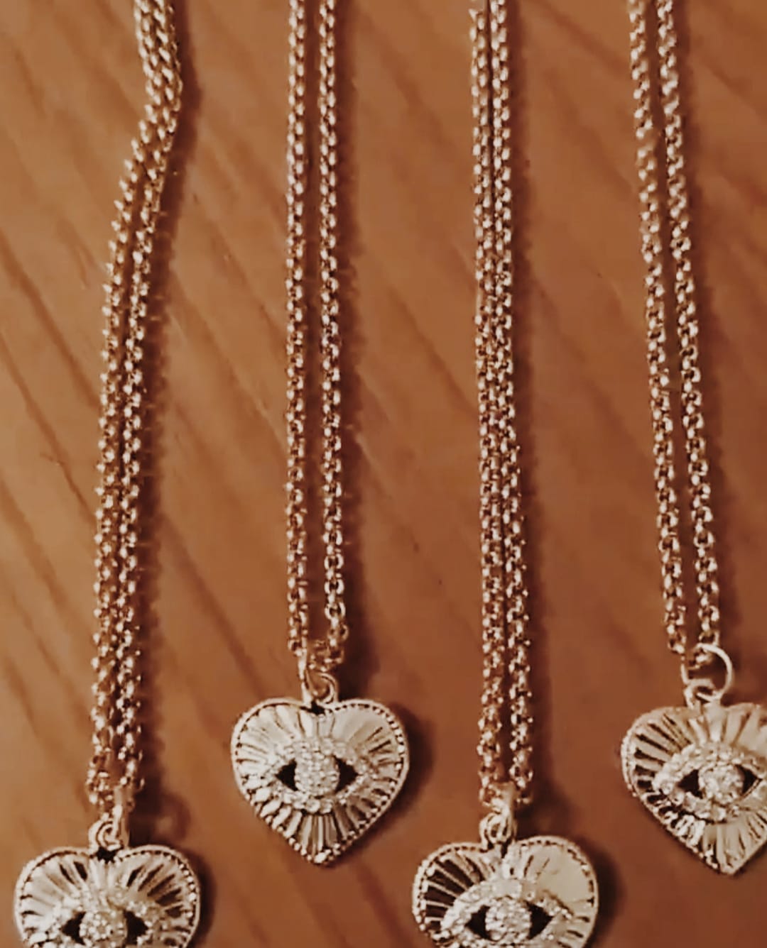 Colar com fio fino em aço com pendente em forma de coração com olho no centro, em cobre e zircónias