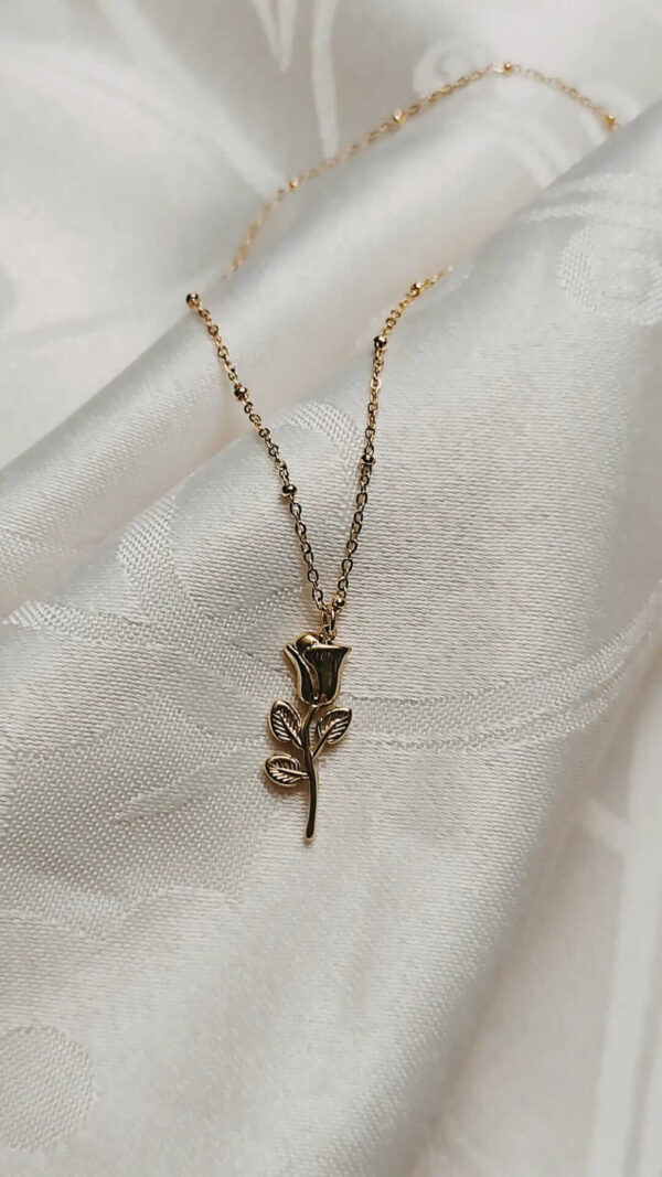 Colar em aço com pequenas esferas no fio e pendente em forma de flor