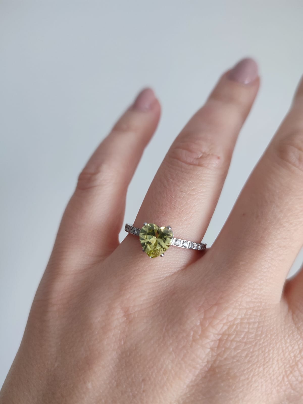 Anel em aço com zirconias transparentes em parte do anel e pedra em forma de coração na cor verde