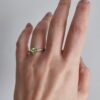 Anel em aço com zirconias transparentes em parte do anel e pedra em forma de coração na cor verde