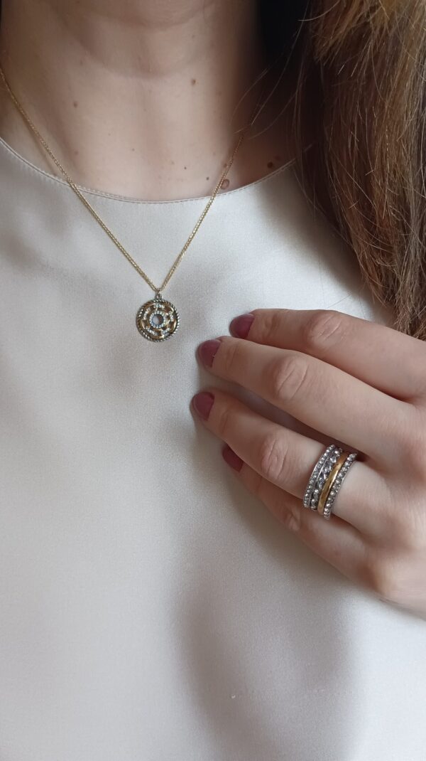 Anel em aço prateado escurecido e dourado, com duas fileiras de zirconias