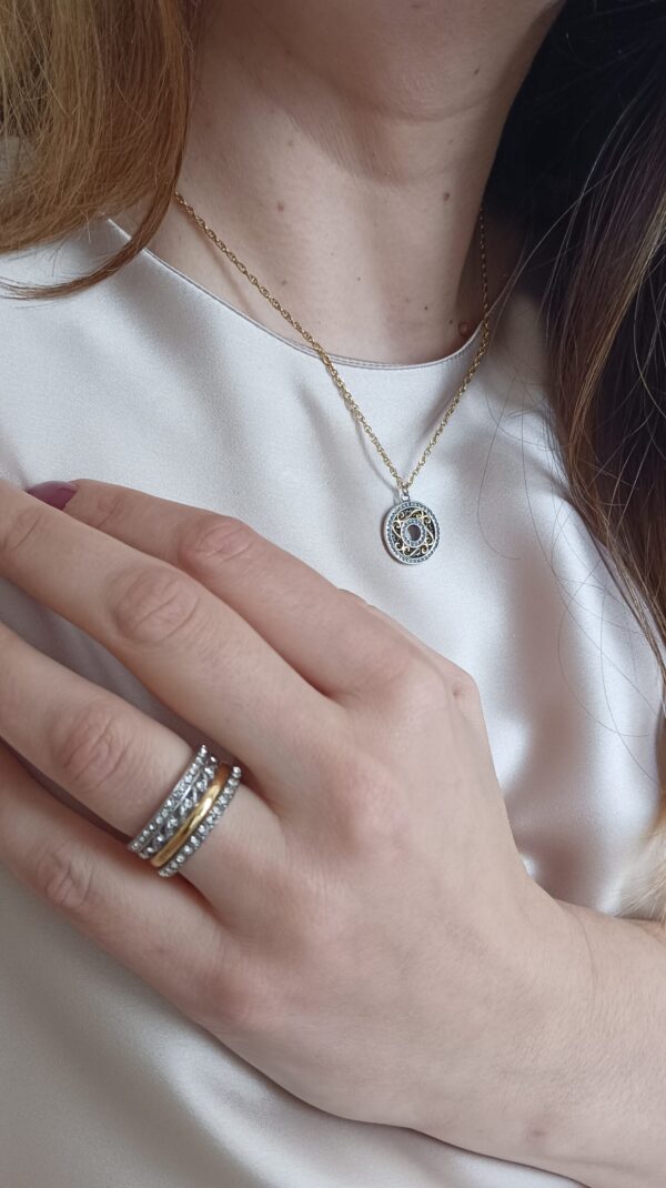 Colar em aço prateado escurecido e dourado com pendente circular com zirconias
