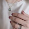 Colar em aço prateado escurecido e dourado com pendente circular com zirconias
