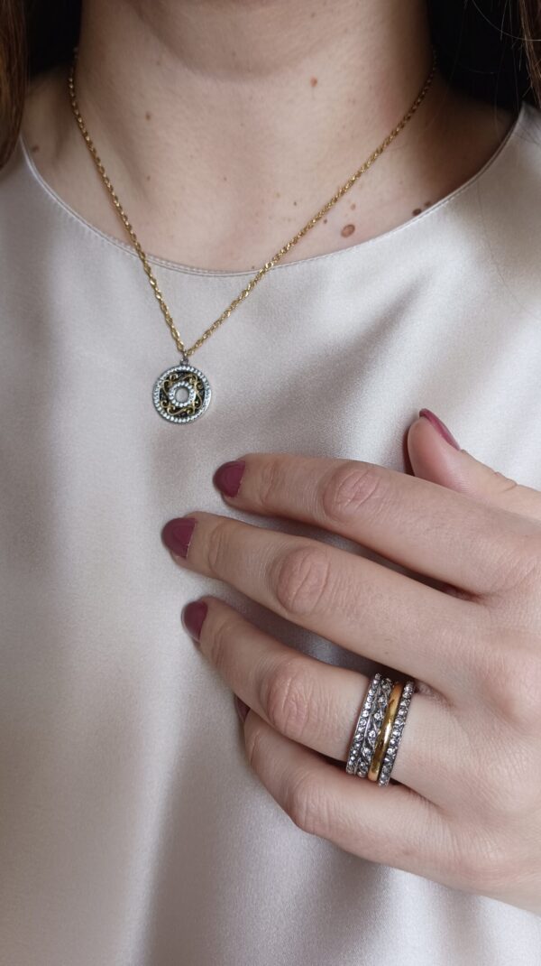 Colar em aço prateado escurecido e dourado com pendente circular com zirconias