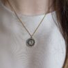 Colar em aço prateado escurecido e dourado com pendente circular com zirconias