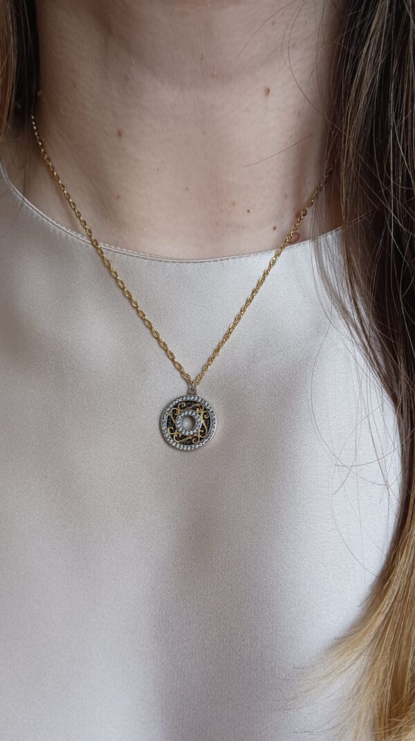Colar em aço prateado escurecido e dourado com pendente circular com zirconias