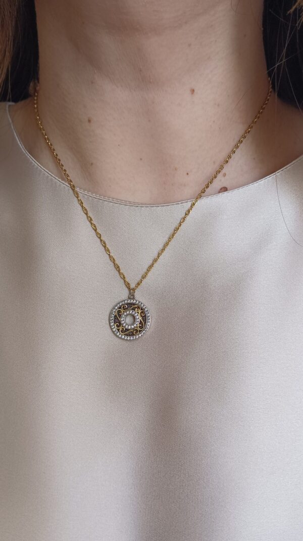 Colar em aço prateado escurecido e dourado com pendente circular com zirconias