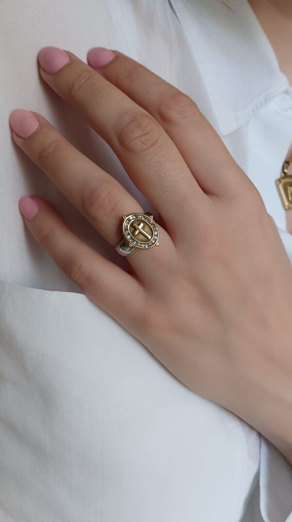 Anel em aço prateado e dourado, oval com cruz e brilhantes ao centro