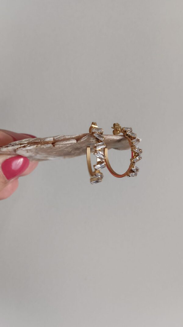 Argolas em aço com pedras brilhantes em parte da superfície