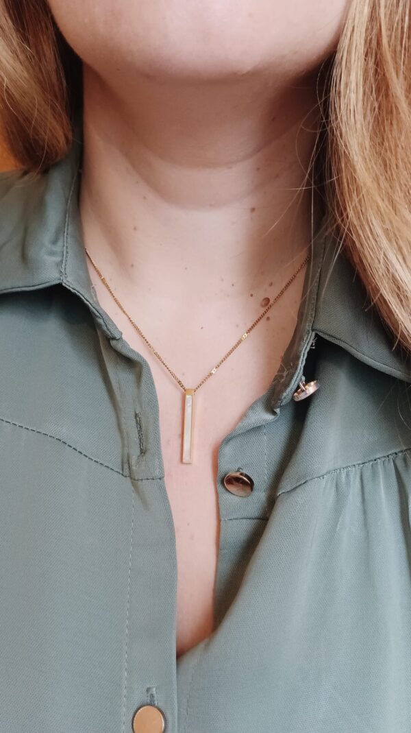 Colar em aço com pendente retangular também em aço, com madrepérola de um dos lados, sendo que no caso de ser personalizado com gravação, a mesma ficará do lado oposto à madrepérola.