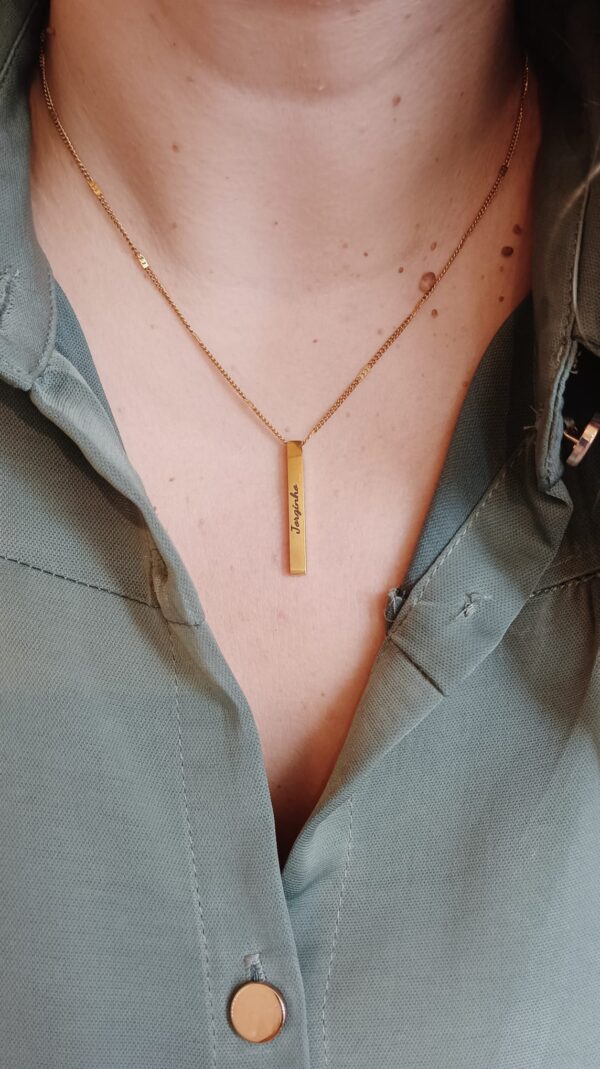 Colar em aço com pendente retangular também em aço, com madrepérola de um dos lados, sendo que no caso de ser personalizado com gravação, a mesma ficará do lado oposto à madrepérola.